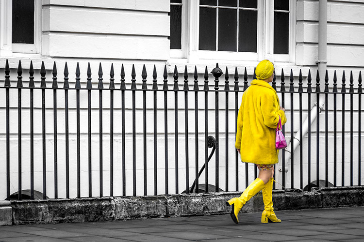 Woman dressed all in yellow on a black and white street