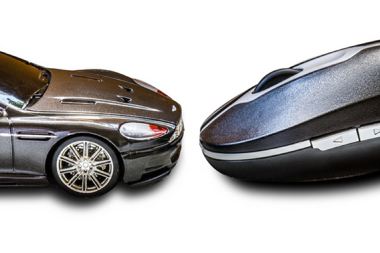 Aston Martin DB7 diecast model facing a computer mouse